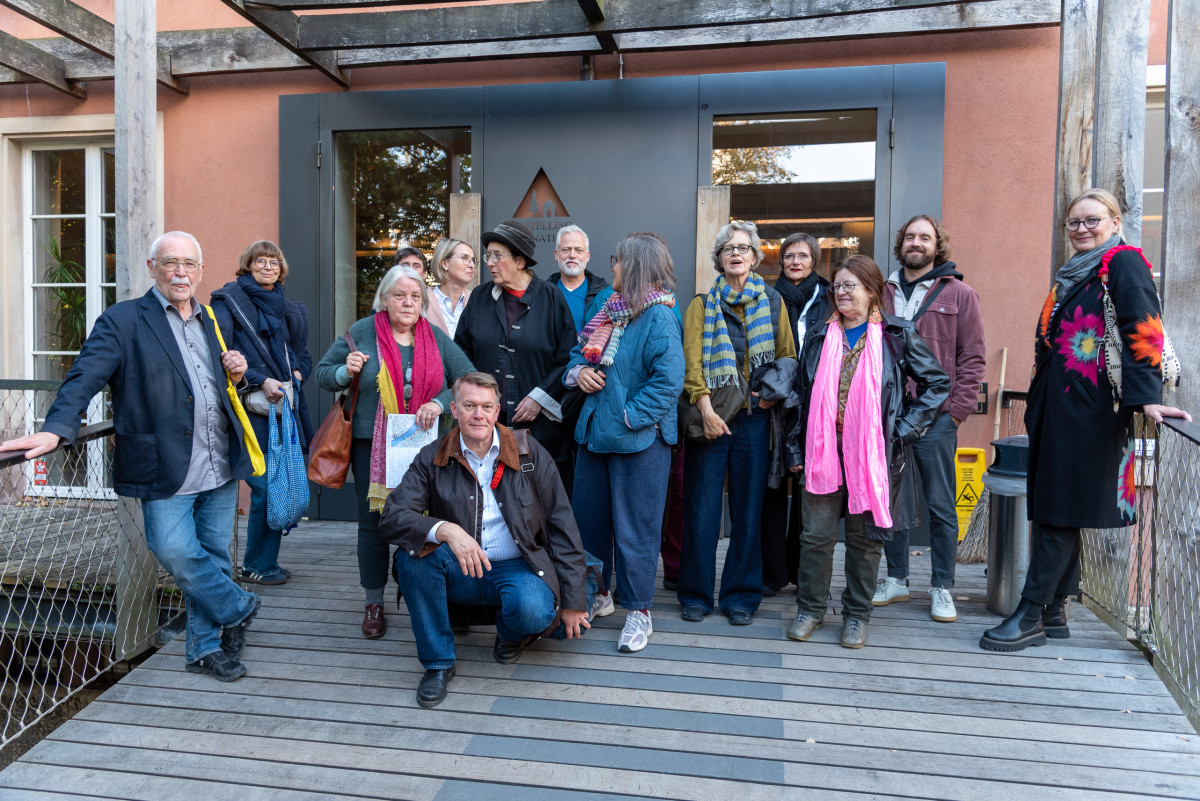 Die Reiseruppe steht vor einem Gebäude und posiert für ein gemeinsames Foto.