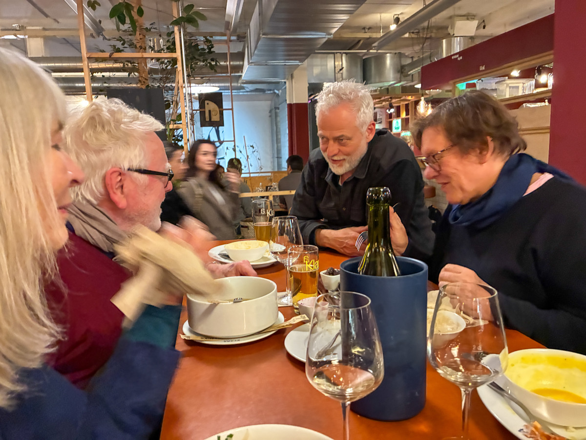 Gruppe von Personen sitzt an einem Tisch im Restaurant, im Gespräch beim Abendessen.