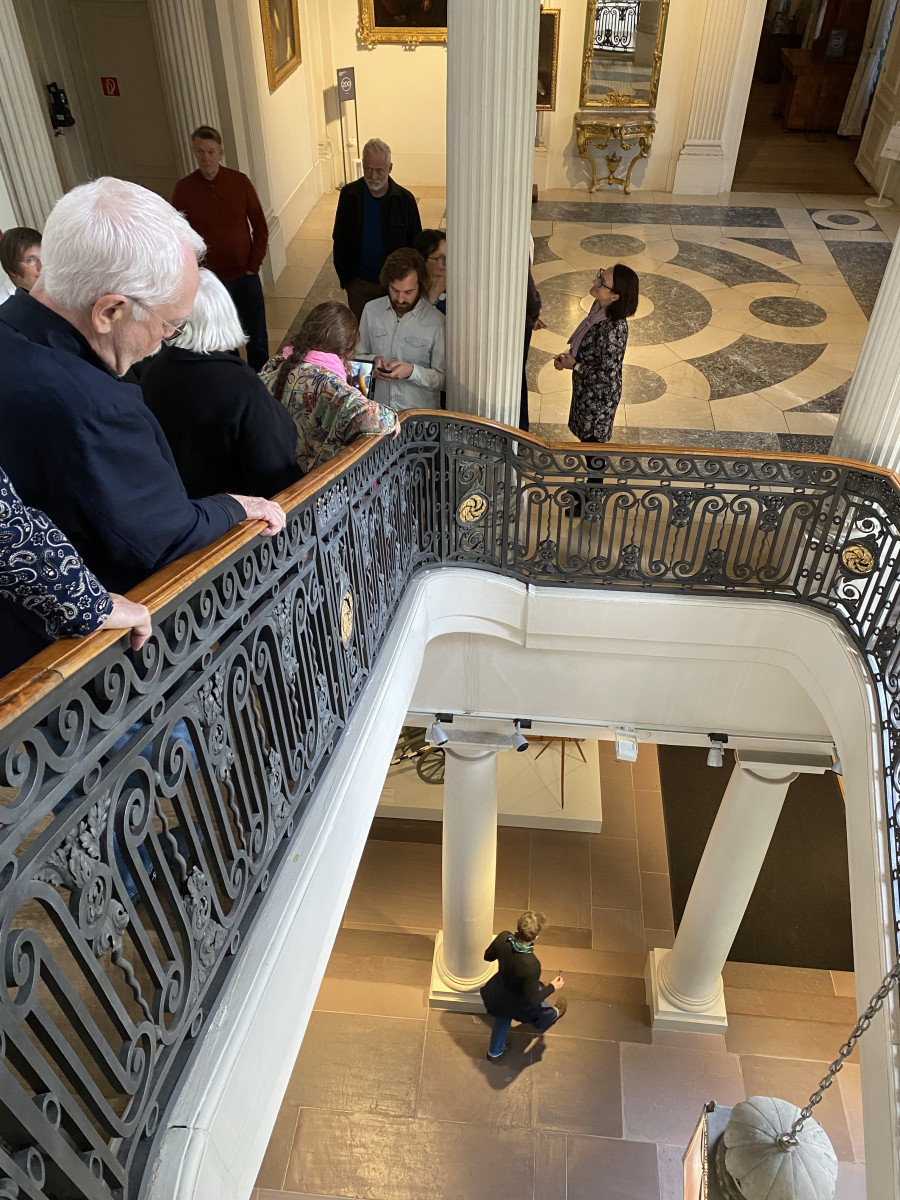 Besucherinnen und Besucher in einem Museum mit klassizistischen Säulen im groß­bür­ger­lichen Anwesen des »Bändel­herren«, mit kunstvoller Marmortreppe.