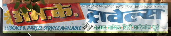Lettering für M.K. Travels. Die Initialen stehen auf rotem Hintergrund, das bengalische Wort für „Reisen“ ist blau auf einer geschwungenen Grundlinie geschrieben.